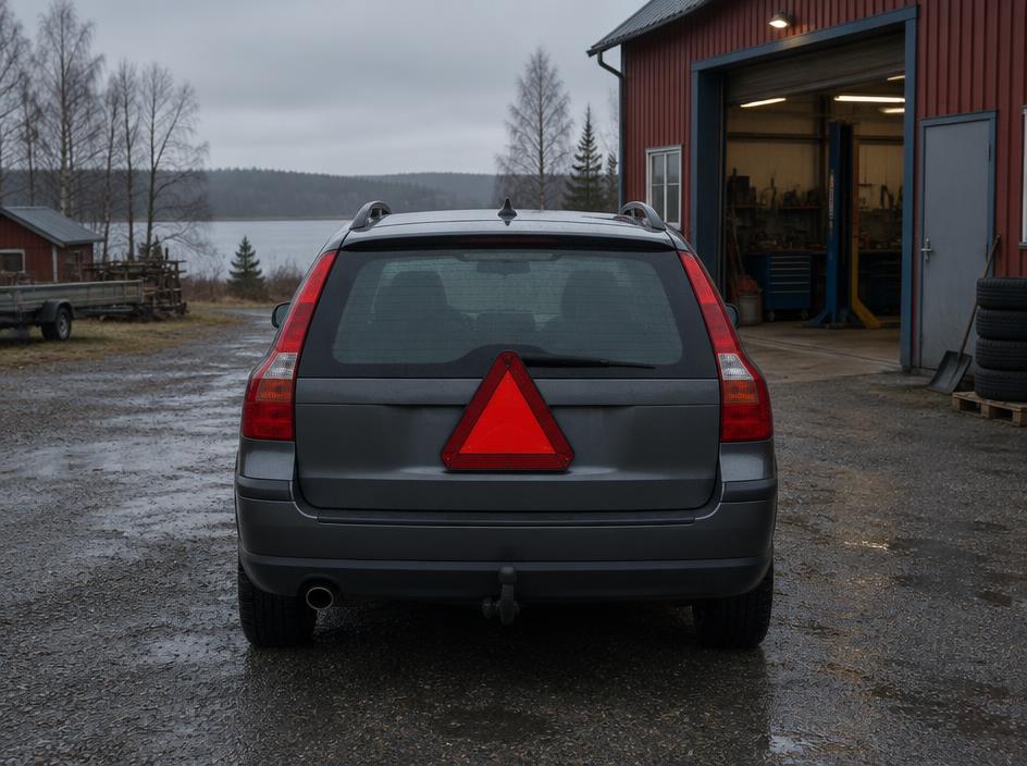 Kombi med LGF-skylt utanför en verkstad